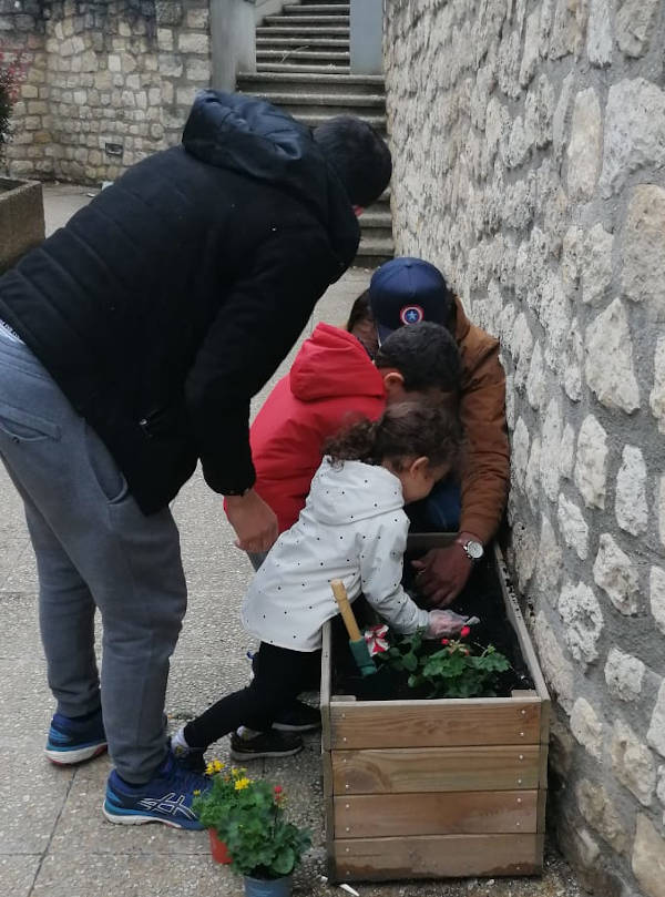 Petits enfants jardinant avec aide des adultes