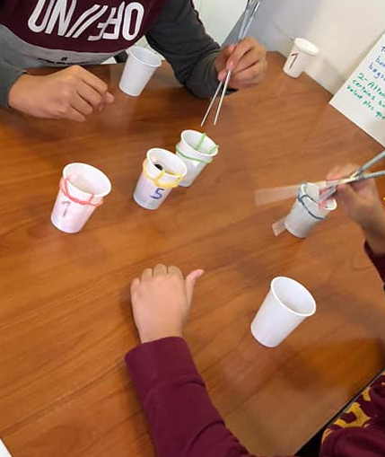 Photo enfants attrapant des bonbons dans un gobelet avec des baguettes